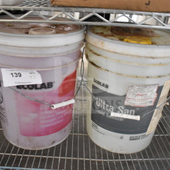Two Ecolab barrels on a shelf; Ultra Klene Detergent and Ultra San Liquid Sanitizer. Auction tag indicating "2 Times Your Bid."