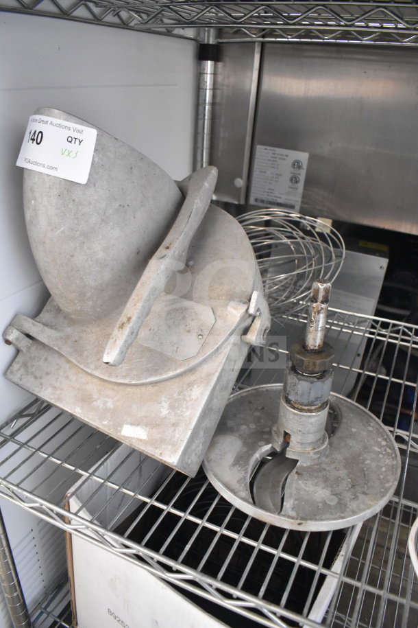 Three items on a metal rack include a Pelican head with label, S blade, and whisk attachment, all in used condition.