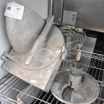 Three items on a metal rack include a Pelican head with label, S blade, and whisk attachment, all in used condition.