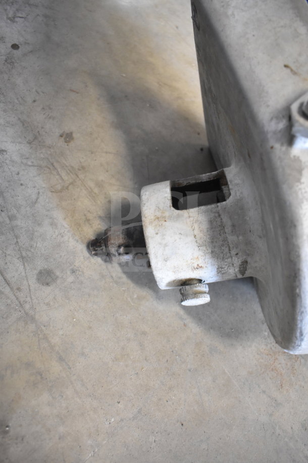 Pelican head attachment in used condition, featuring a visible mounting bracket on a concrete floor.