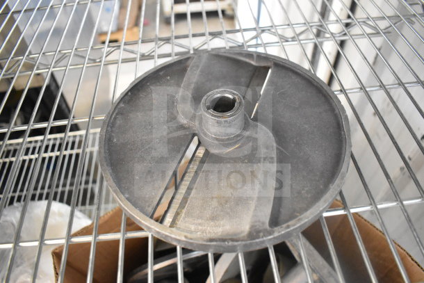Various food processor blades, visible wear, placed on wire shelf. Part of an auction lot of 20 different items.