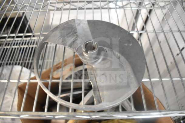 Metal food processor blade on a shelf, part of a lot of 20 various items, condition appears used.