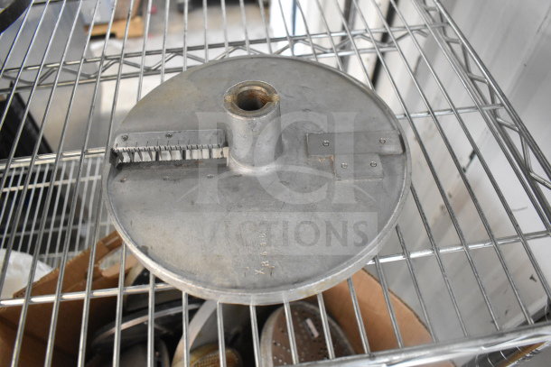 Metal food processor blade on wire rack; part of auction lot with 20 various items. Blade features and wear visible.