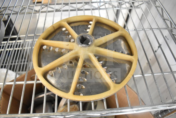 Food processor blade on metal rack, circular with beige plastic spokes, showing some wear. Part of a 20-item auction lot.