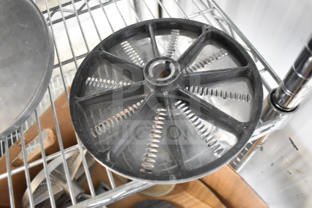 Set of 20 food processor blades, including various styles, displayed on metal shelving. Good condition.