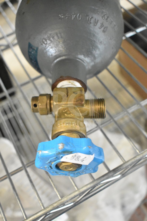 Carbon dioxide tank with brass valve and blue handle. Visible engravings on the handle and tank. Buyer must pick up.