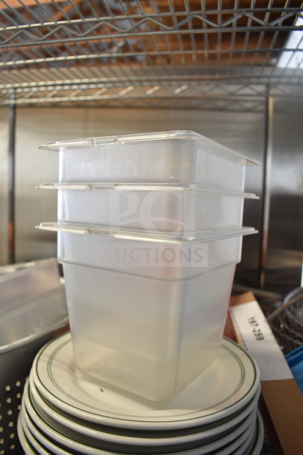Stack of plastic containers on a set of white plates with green rim, accompanied by a metal colander. Multipurpose kitchen lot.