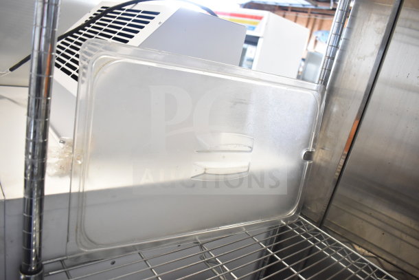 Clear plastic food pan cover on a metal shelf. Condition appears used. Part of tier lot including kitchenware items.