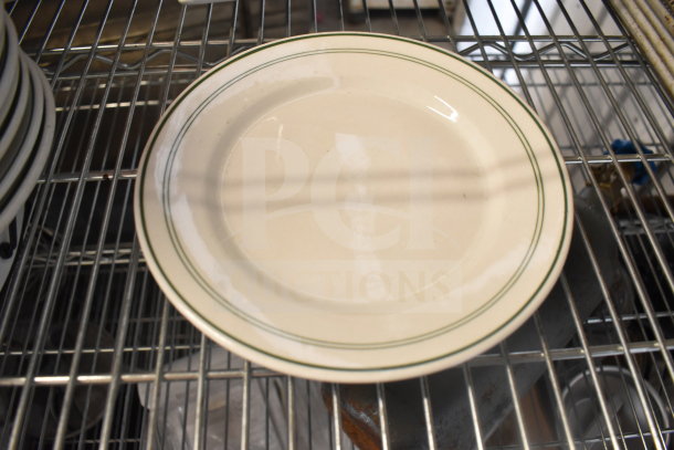 Round ceramic plate with green rim lines, in good condition, part of an auction lot with various kitchen items.