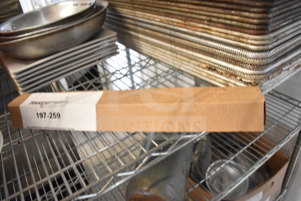 Tiered lot including metal colander, stack of plates, and baking pans on a metal rack. Box labeled "197-259" visible.