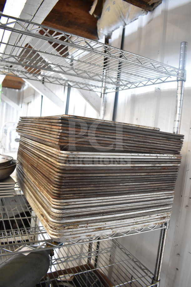 Colander, plates, and baking pans on metal shelves, showing wear. Ideal for bulk kitchen purchase.