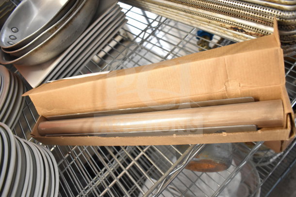 Alt text: Tier lot with various kitchen items including a metal colander, stacked plates, baking pans, and a boxed rolling pin.
