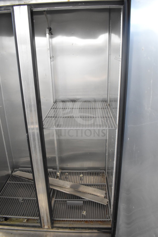 2017 True T-35 commercial cooler, two doors, metal shelves. 115 volts, 1 phase. Shows moderate wear, clean interior.