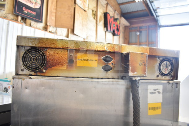 Commercial heated holding cabinet, model HU18-671-120, on casters. Noticeable wear and rust present. Power switches shown.