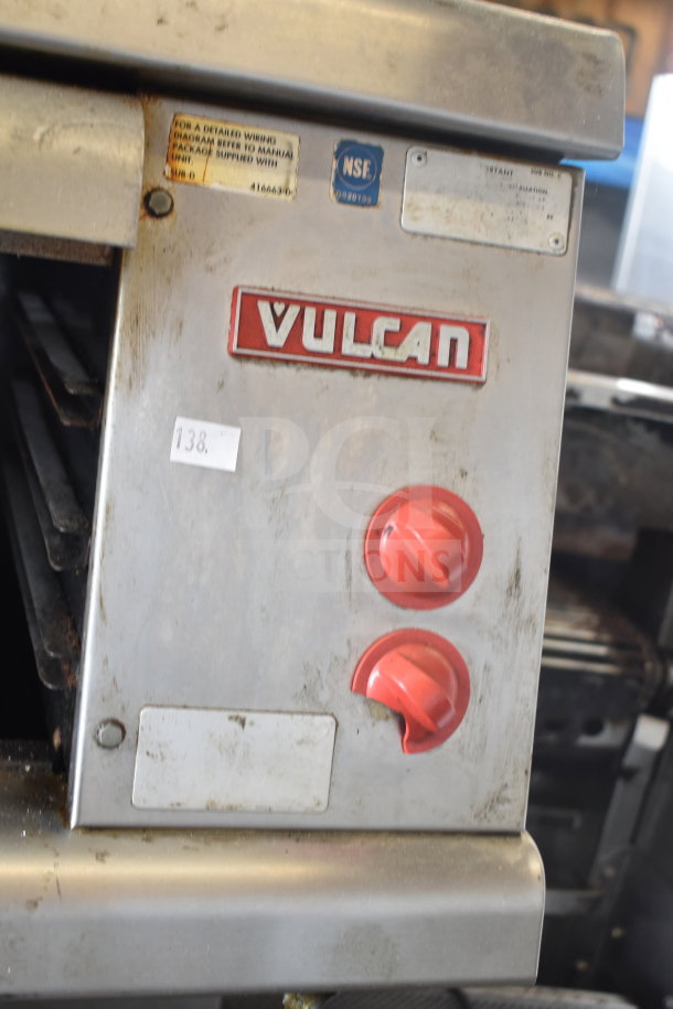 Vulcan ESB60 electric 10-burner range with two ovens, over-shelf, and backsplash. Features red control knobs, visible ware.