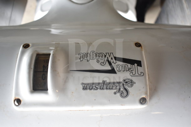 Vintage Stimpson Scale, marked "True Weight," with visible dial. In used condition, features classic design with logo.