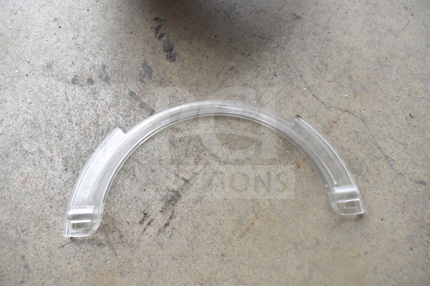 Close-up of a clear plastic bowl guard for a KitchenAid KSM90PSWH mixer on a concrete surface.