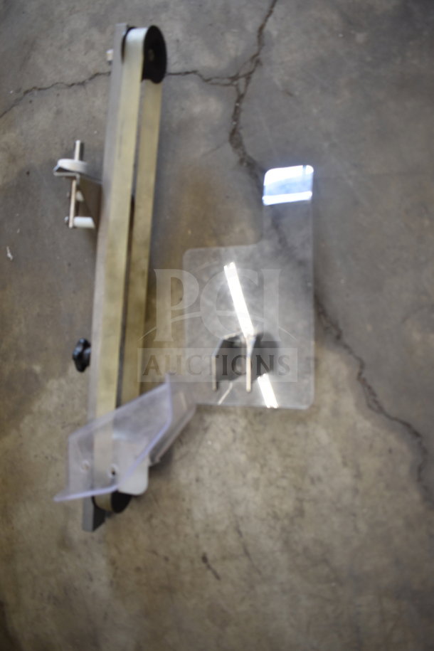 ChocoVision Revolation X3210 Chocolate Tempering Machine parts on a concrete floor. Includes metal and plastic components.