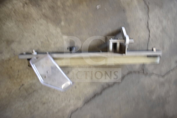 Blurry image of metal machinery part on concrete floor, possibly related to a larger equipment assembly.