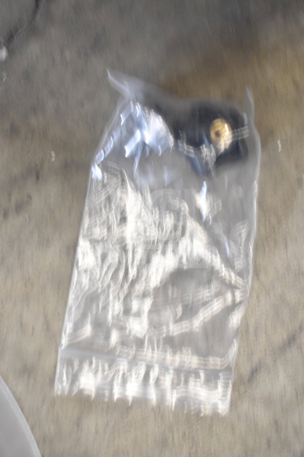 Blurry image of a ChocoVision Revolation X3210 Chocolate Tempering Machine component in a plastic bag.