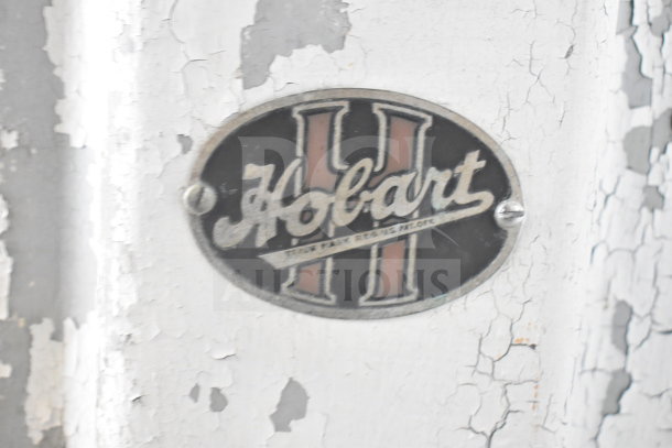 Hobart Commercial Floor Style Meat Saw logo on weathered surface, showcasing brand authenticity.