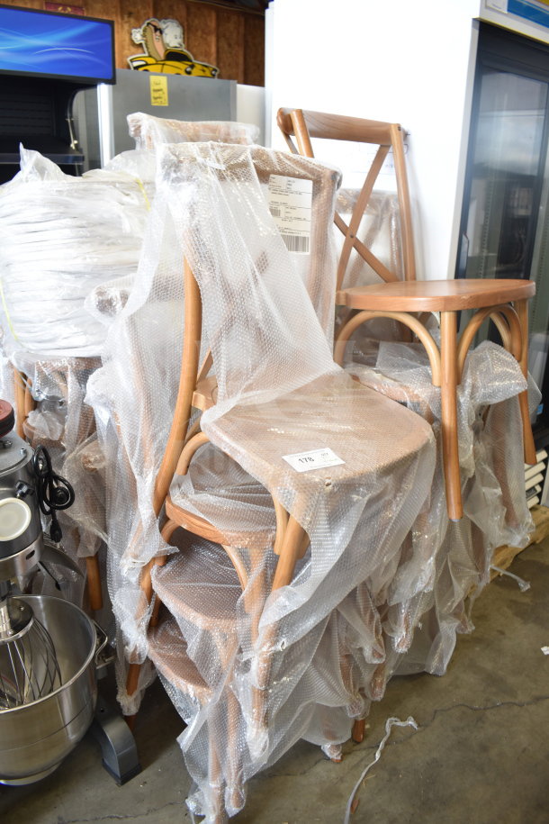 Set of 17 new Flash Furniture cross back chairs, wood pattern, partially wrapped in bubble wrap, includes cushions.