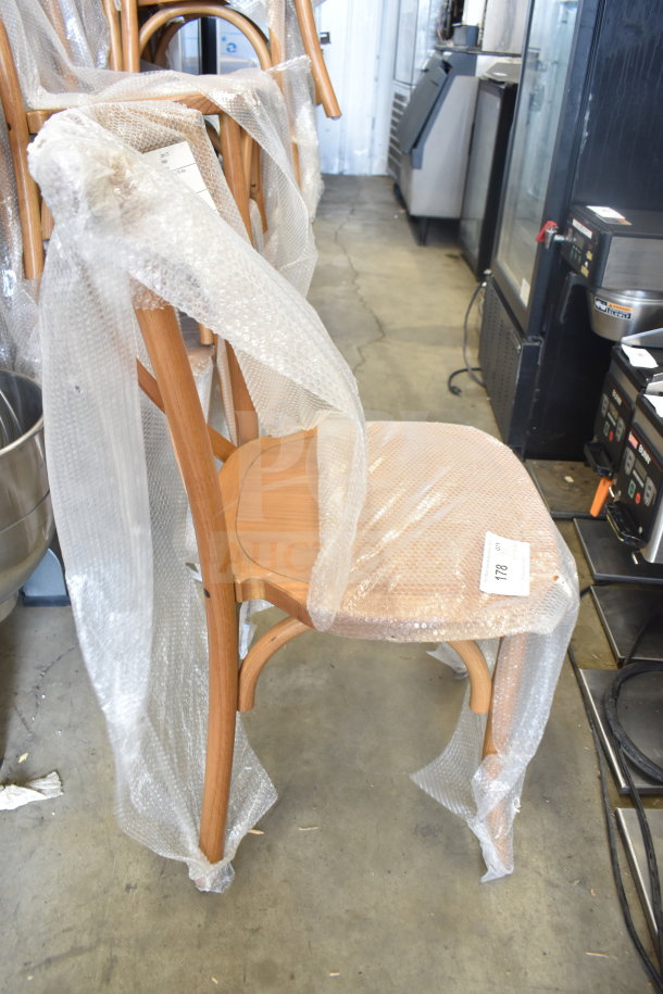 Brand new Flash Furniture wood pattern cross back chair wrapped in bubble wrap. Scratch and dent condition, visible tag marked "178".