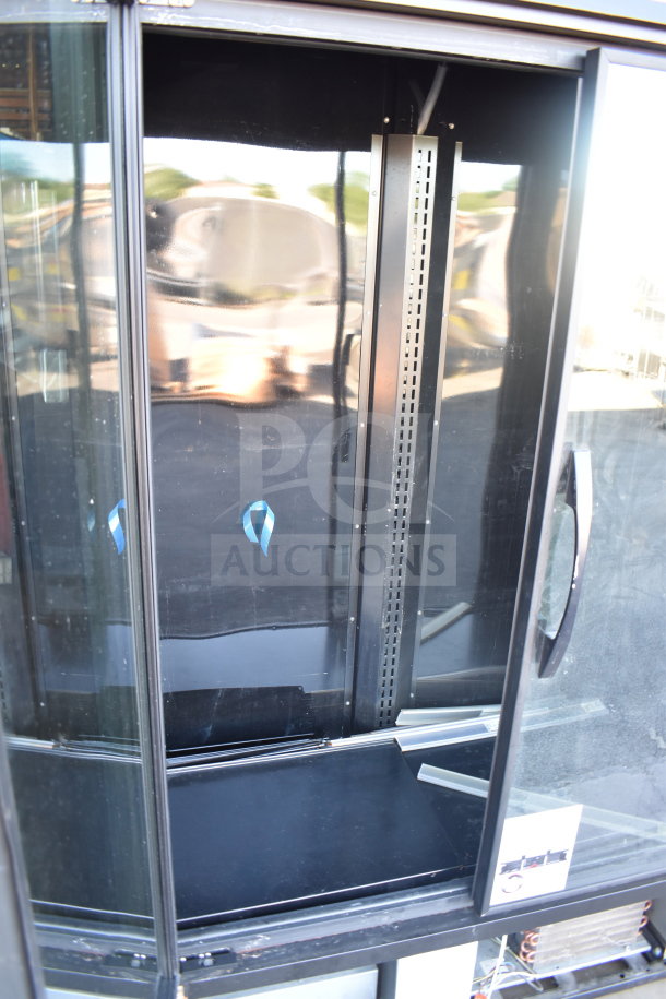 2021 True TVM-48SL-HC Commercial 2 Door Reach In Cooler, glass front, black interior, 115V, 1 Phase. Visible shelving brackets.