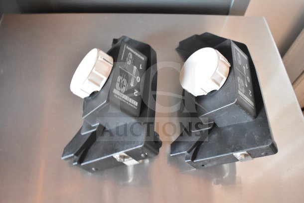 Two meat slicer sharpeners, black with white knobs, marked with sharpening instructions. Condition appears good.