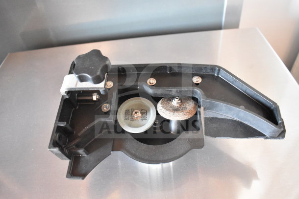 Meat slicer sharpener in black casing with visible grit wheel, labeled "Bizerba." Appears in good condition.