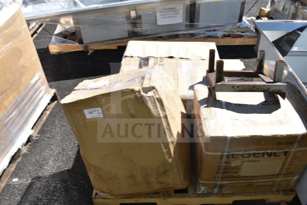 Boxes of scratch and dent items on a pallet, visible labels include Regency and Lancaster, indicating contents include an underbar sink and a live edge table top.