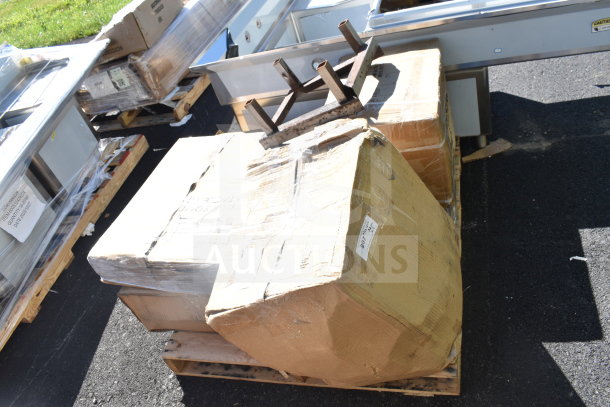 Auction items on pallets include a Regency hand sink, Lancaster table top, and utility cart. Boxes show signs of wear.