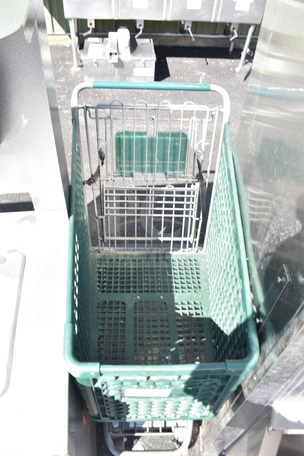 Green shopping cart with metal frame, plastic basket, handle, and swivel wheels. Appears to be in used condition.