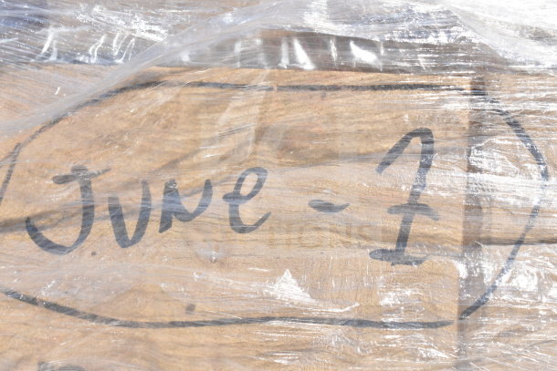 Clear plastic wrap with handwritten text "June-7" on wooden surface. Auction of 10 new scratch and dent items, including shelves.