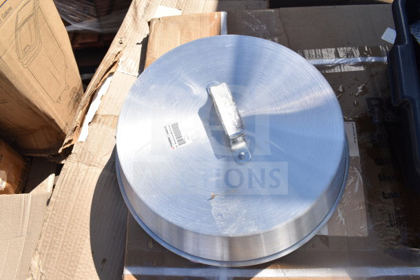Aluminum wok cover with handle on cardboard box, visible barcode and label, part of a scratch and dent auction lot.