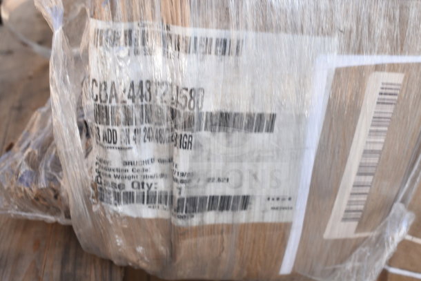 Pallet wrapped in plastic containing assorted scratch and dent items, visible label shows barcode and item code.