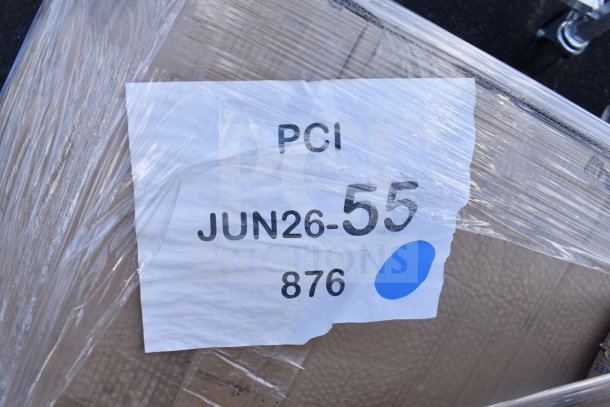 Plastic-wrapped package labeled "PCI JUN26-55 876" with blue dot, part of an auction lot of 12 scratch and dent items.