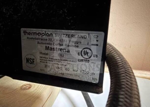 Thermoplan Mastrena CS2 espresso machine tag showing UL/NSF listing, 208V, model and serial number details.