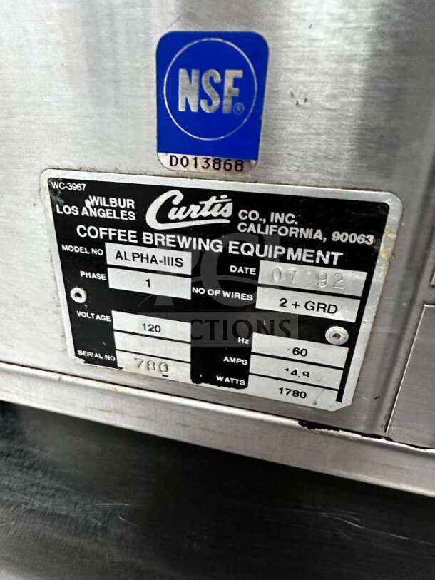 Wilbur Curtis ALPHA-IIIS coffee brewer label, showing model, serial, voltage, and NSF certification for commercial use.