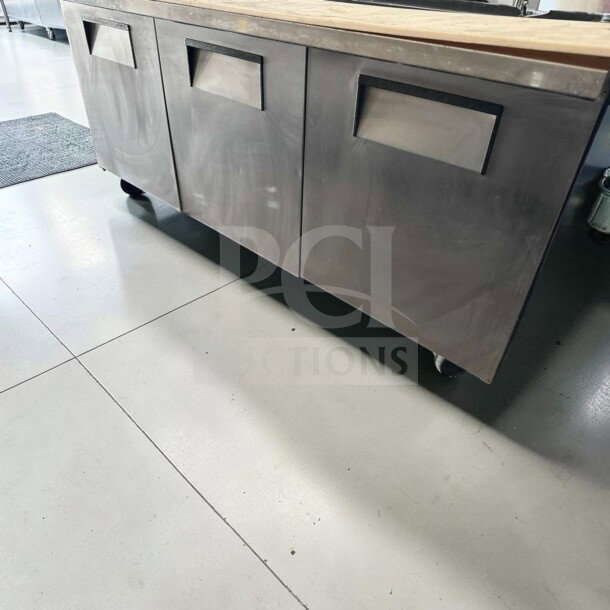 True TSSU-72-30M-B-ST-HC refrigerated prep table in exceptional condition with stainless steel base and wheels.