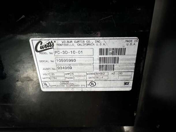 Wilbur Curtis PC-3D-10-01 label shows model, serial, and voltage details. Made in USA, NSF certified cappuccino dispenser.
