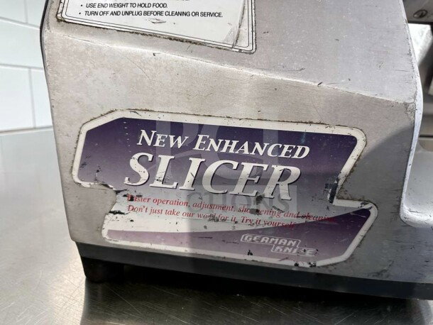 German Knife GS-12M Slicer, 12", heavy-duty, gravity feed, 1/2 HP, fully operational, visible label stating "New Enhanced Slicer."