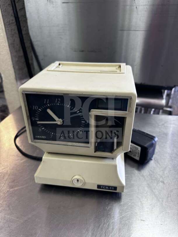 AMANO TCX-11 time clock recorder, model 5477, in prime condition. Features automatic time stamp, fully operational.