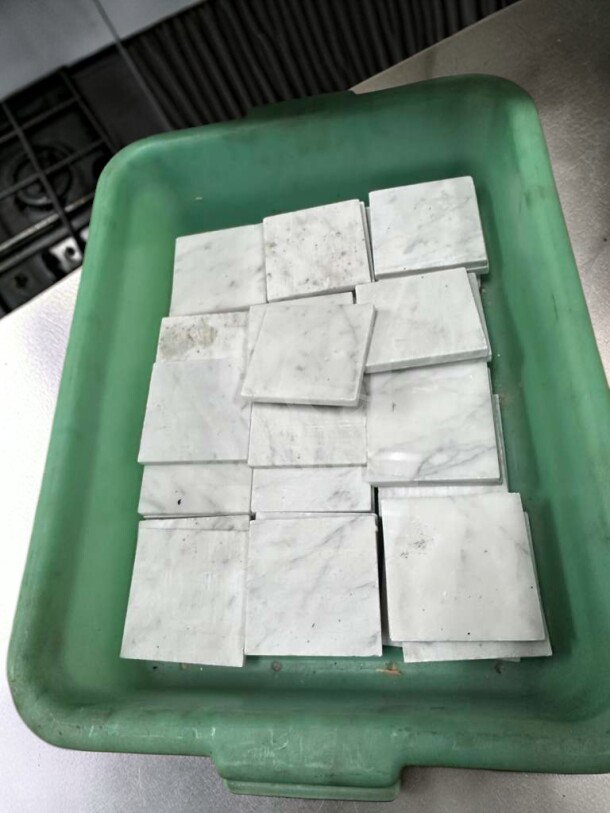 Outstanding condition Carrara White Marble 4x4 honed tiles in a green container. Ideal for interior walls and backsplashes.