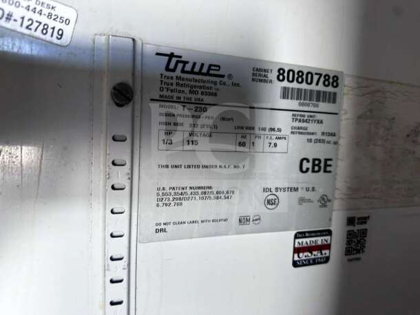 Label on a True T-23G-HC~FGD01 commercial refrigerator, highlighting model, voltage, refrigerant info, and NSF certification.