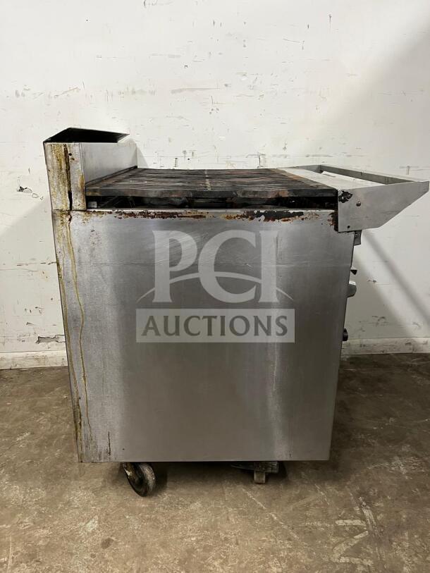 Jade Range Oven with 6 Burners, 35000 BTU, stainless steel, visible wear and rust, model unknown, on casters.