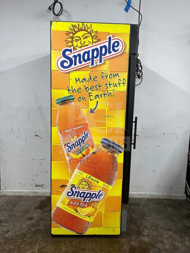 TRUE GDM-19T-LD 27" black refrigerated glass door merchandiser with Snapple branding, LED lighting, and travel case.