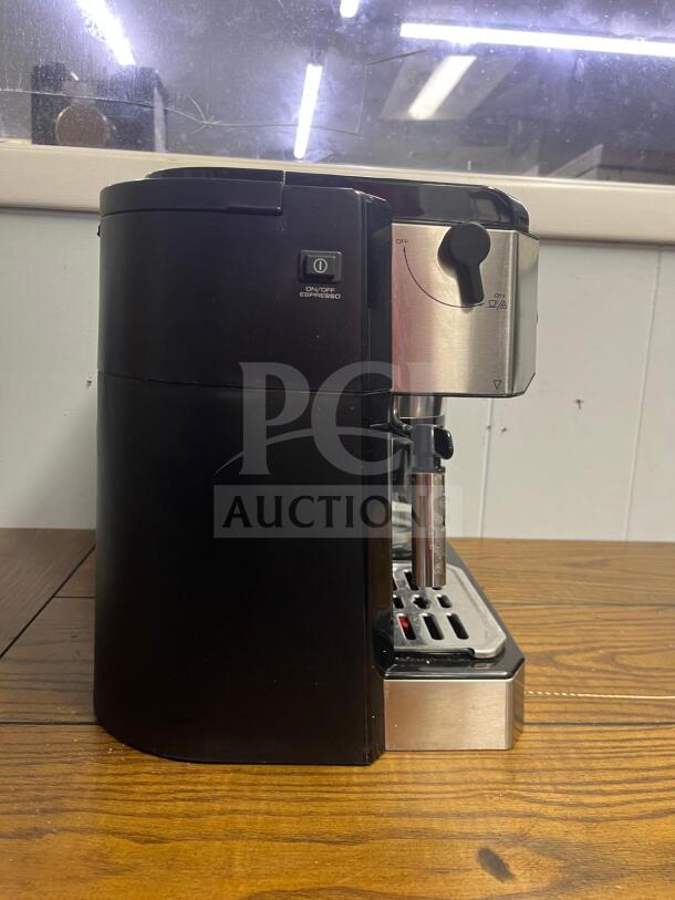 DELONGHI BCO430 combination espresso and drip coffee machine, silver and black, frothing wand, on/off switch visible.