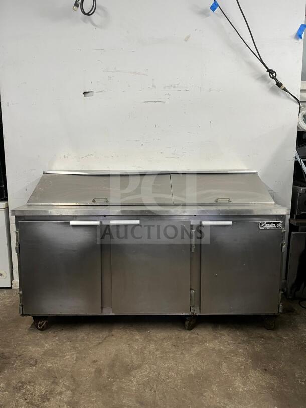 LEADER NSFM72 72" 3-door refrigerated prep table, stainless steel, used condition, caster wheels, brand logo visible.