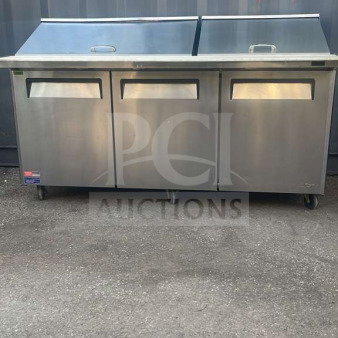 Turbo Air MST-72-30-N 72" stainless steel refrigerated prep table with three doors, mega top, on rolling casters.
